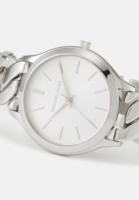 Ceas de mână Michael Kors argintiu, cu cadran alb, marcaje subțiri pentru ore și brățară metalică legată, indicând ora 2:40:18.