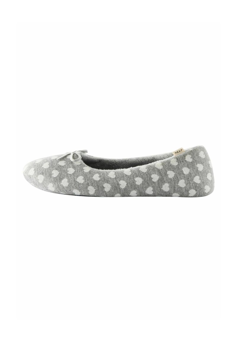 Grijze slipper met een wit hartpatroon, ronde vorm, zachte stof en een strikdetail aan de voorkant. Lichtgewicht en plat ontwerp.