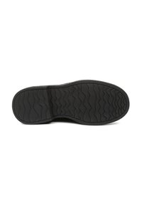 Suela de zapato de goma negra con una textura ondulada. Patrón de banda de rodadura notable para agarre, con bordes redondeados y un acabado suave en la punta.