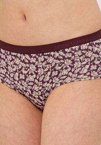 Boxeri pentru femei cu un model floral în nuanțe burgund, având un brâu moale, ce prezintă o combinație de tonuri deschise și închise în design și o textură din bumbac.