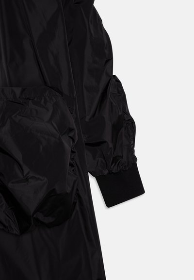 Black puffer jacket with a shiny, smooth texture, featuring voluminous sleeves, ribbed cuffs, and large side pockets.