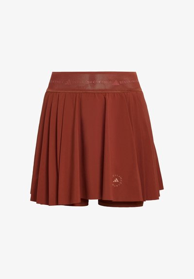Faltenrock in Rostfarbe aus Tennisstoff mit breitem elastischem Bund, integrierten Shorts und kleinem runden Adidas by Stella McCartney-Logo nahe dem Saum.