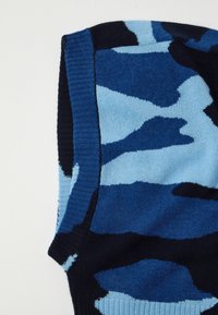 Pletená čepice v různých modrých odstínech s camo vzorem. Měkká textura s žebrovaným okrajem pro bezpečné uchycení. Střední tloušťka.