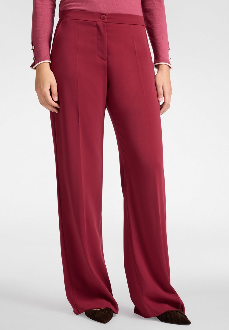 Pantalones de pierna ancha burdeos, hechos de una tela suave, con cierre de botón en la parte delantera, bolsillos laterales y un ajuste entallado.