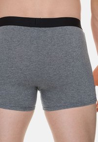 Boxer in cotone grigio con elastico nero in vita, caratterizzati da una texture liscia e un design aderente che offre comfort e copertura.