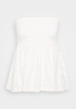 Top bianco senza spalline con un corpino texturizzato e arricciato. La gonna presenta dei dettagli in pizzo e tessuto arricciato. Design leggero e arioso.