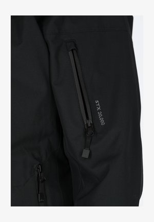 Black waterproof jacket with adjustable zippered pockets, smooth texture, and "STX 20.000" lettering near the pocket.