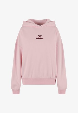 Kerge roosa kapuutsiga särk, ribakäised ja sobiv vöökoht. Rinnal on tumeroosa logo. Pehme puuvilla segu kangas.