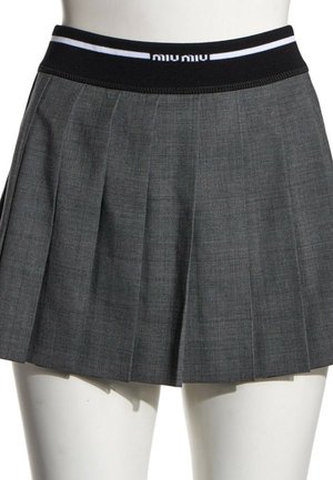 Jupe plissée gris foncé avec taille élastique noire comportant des bandes blanches et un texte partiel de logo blanc sur un mannequin.