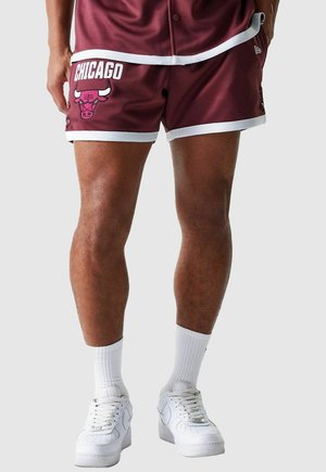 Maroon basketball shorts with white accents, featuring "CHICAGO" text and a bull logo. Made of smooth fabric, with side buttons and a relaxed fit.