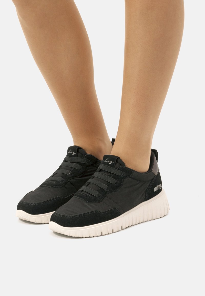 Zapatillas negras con un upper de tela texturizada, diseño de cordones y una suela de goma blanca con un patrón acanalado. Con detalles de logotipo.