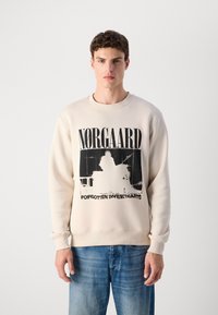 Cream-colored sweatshirt made of soft material, featuring a black graphic print and text "NØRGAARD FORGOTTEN SWEETHEARTS." Crew neck design.