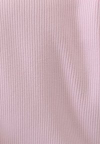 Tessuto rosa pallido con una texture rigata, che sfuma sottilmente nel tono e nella luce, creando un aspetto delicato e accogliente.