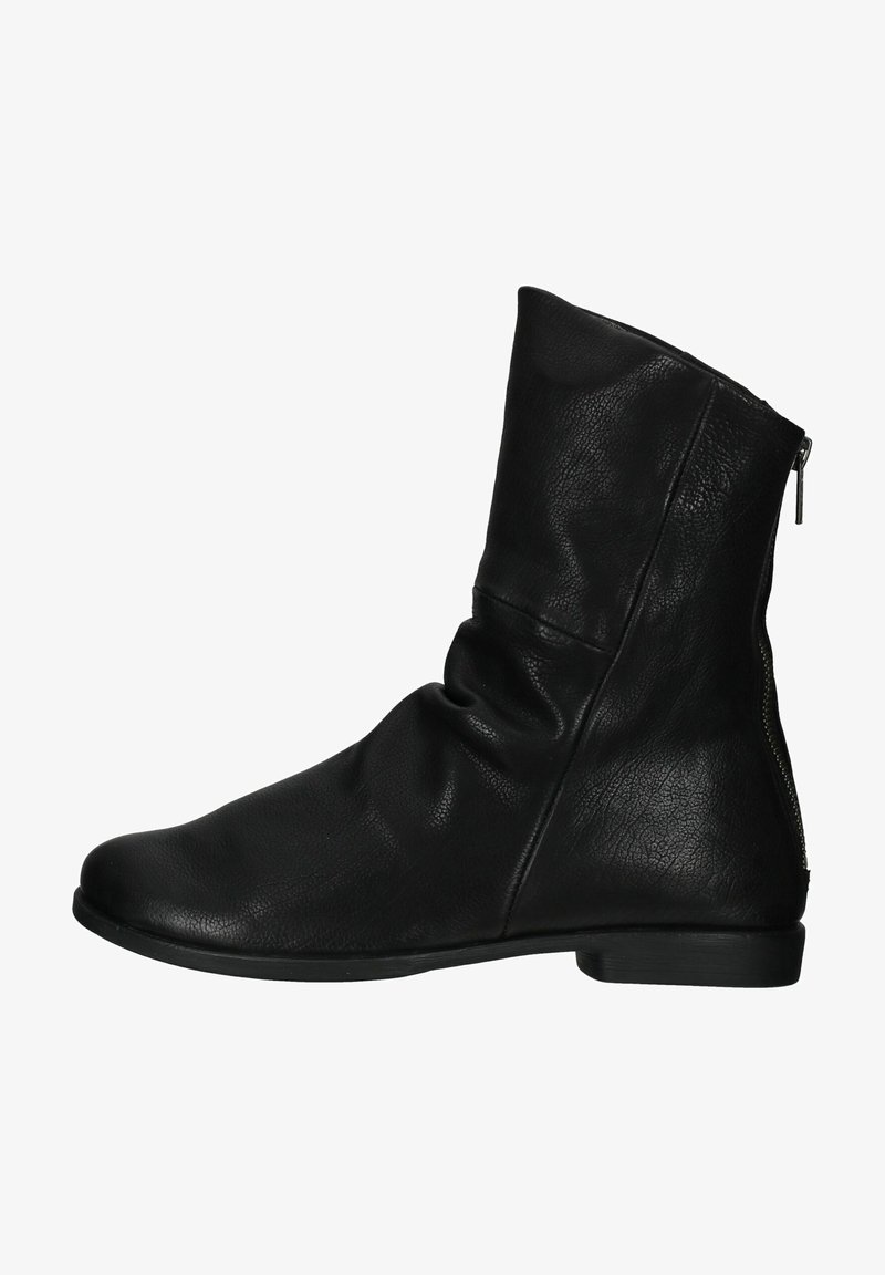 Botte noire en cuir à la cheville avec un design légèrement tombant, détails de fermeture éclair sur le côté, bout rond et semelle plate. Surface texturée avec un grain visible.