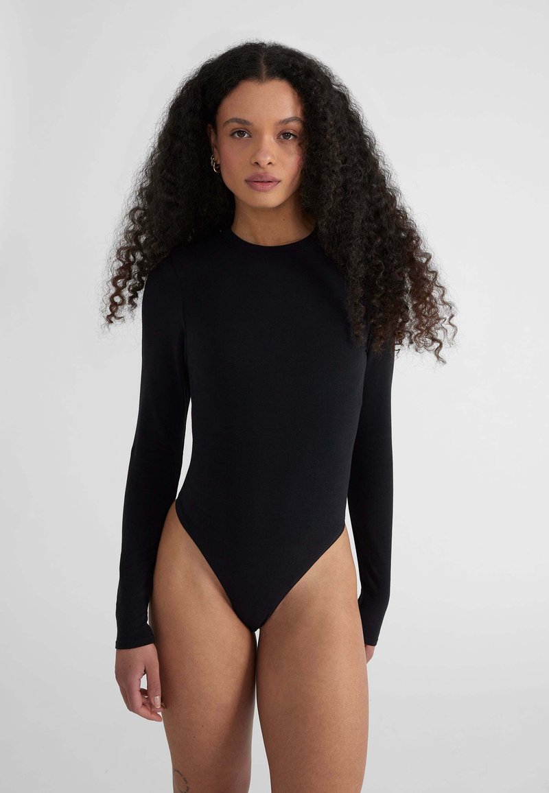 Bodysuit negro de manga larga hecho de una tela suave, con un alto escote y aberturas laterales de pierna elevadas para una silueta elegante.