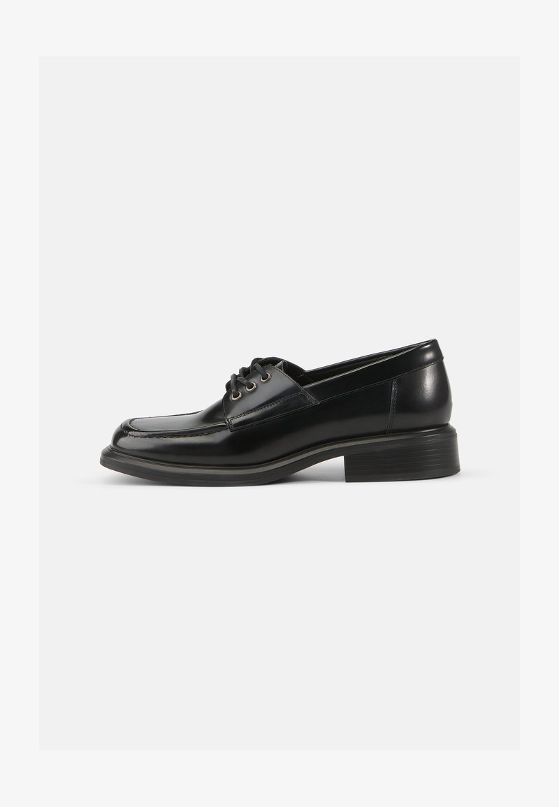 Sapatilha de couro preto com uma textura suave, bico arredondado, atacadores com duas ilhós e um salto em bloco resistente. Design simples sem padrões.