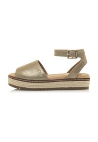 Sandalias metálicas doradas con una amplia tira en los dedos, tira en el tobillo con hebilla y una suela plataforma de yute trenzado. Suela plana con textura para mayor agarre.