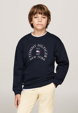 Felpa blu navy con maniche lunghe, scollo rotondo e logo bianco "TOMMY HILFIGER EST. 1985 NEW YORK" stampato sul davanti.