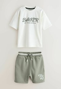 Biała koszulka z krótkim rękawem z napisem "BAKER BY TED BAKER" w zestawie z szarymi szortami ze ściągaczem, na których nogawce znajduje się logo "TB BAKER".