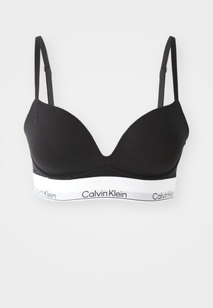 Black fabric bralette with smooth, molded cups, adjustable straps, and a white elastic band featuring "Calvin Klein" logo.