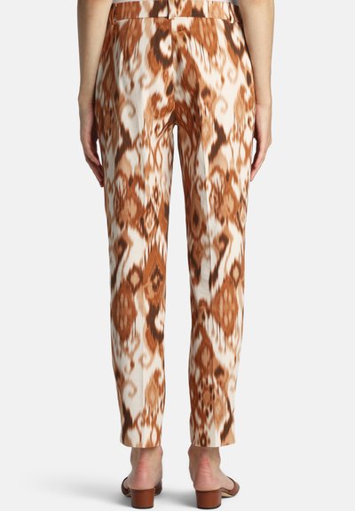 Pantalon avec un motif ikat marron et crème, conçu avec une coupe droite, une texture lisse et une taille mi-haute.