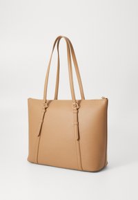 Borsa tote color tan realizzata in materiale simile alla pelle, dotata di due manici lunghi, una forma strutturata e una chiusura superiore con zip e cuciture decorative.