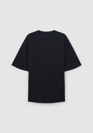 Czarna, oversize koszulka z krótkim rękawem, okrągłym dekoltem, gładką fakturą i bezszwowym tyłem. Brak widocznych wzorów lub grafik.