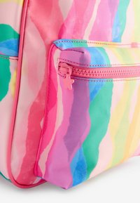 Backpack with a wavy, multicolored pattern in pink, green, yellow, and blue. Features a small zipper with a star-shaped pull. Textured fabric.