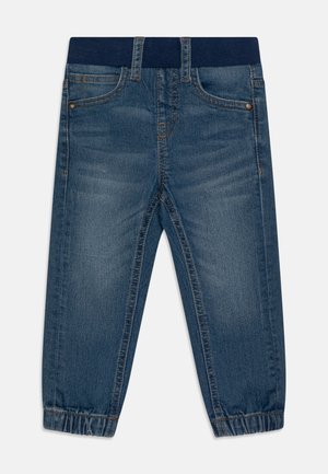 Børneblå denimjeans med elastisk mørkeblå linning, forlommer, bæltestropper og elastiske manchetter på buksebenene.