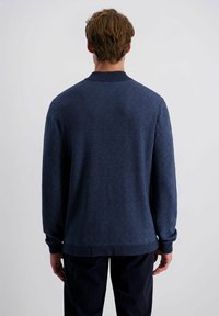 Marineblaue gemusterte Pullover mit einem strukturierten Fischgrätmuster, geripptem Kragen, Bündchen und Saum. Lange Ärmel, lässige Passform.