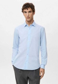 Jasnoniebieska koszula z długim rękawem wykonana z gładkiej tkaniny, z kołnierzem zapinanym na guziki i prostym krojem z przednim plisowaniem na guziki.