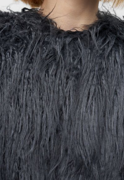 Μαύρο γούνινο ύφασμα με μακριές, μη δομημένες ίνες, δημιουργώντας υφή επιφάνειας. Διαθέτει στρογγυλή λαιμόκοψη, κατάλληλο για εξωτερικά ρούχα.