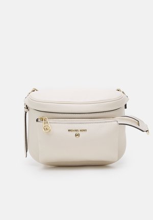 Beige Leder-Gürteltasche von Michael Kors mit einer vorderen Reißverschlusstasche und goldfarbenem Logo-Emblem vor weißem Hintergrund.