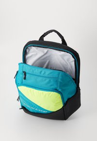 Teal and black backpack featuring a geometric pattern, a front pocket, a zip closure, and a gray interior lining.