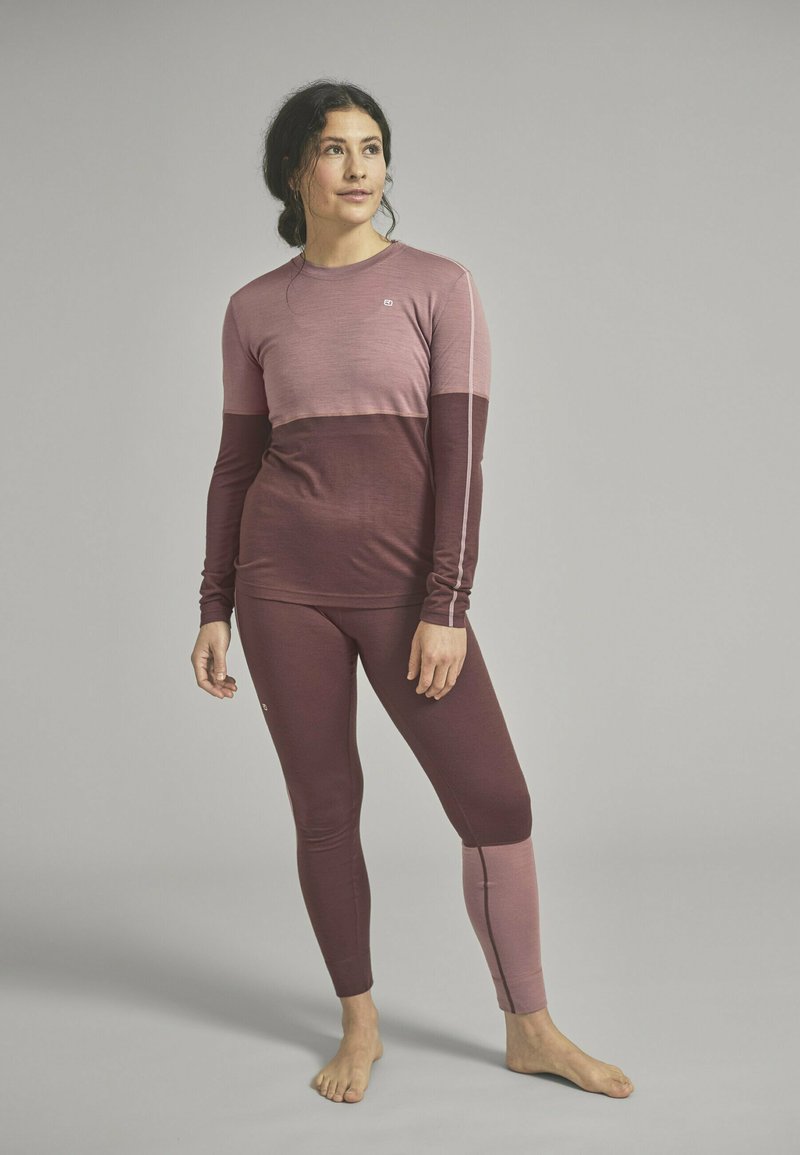 Long-sleeve athletic top and leggings in varying shades of burgundy and pink, featuring a color-block design and contrast stitching.