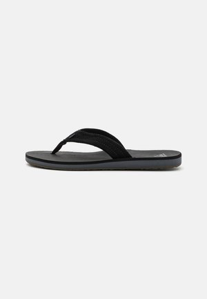 Melnas flip-flops ar teksturētu gumijas zoli, kas aprīkotas ar divām auduma siksnām un viegli mīkstinātu pēdas daļu. Vienkāršs dizains, bez redzamām rakstainēm.