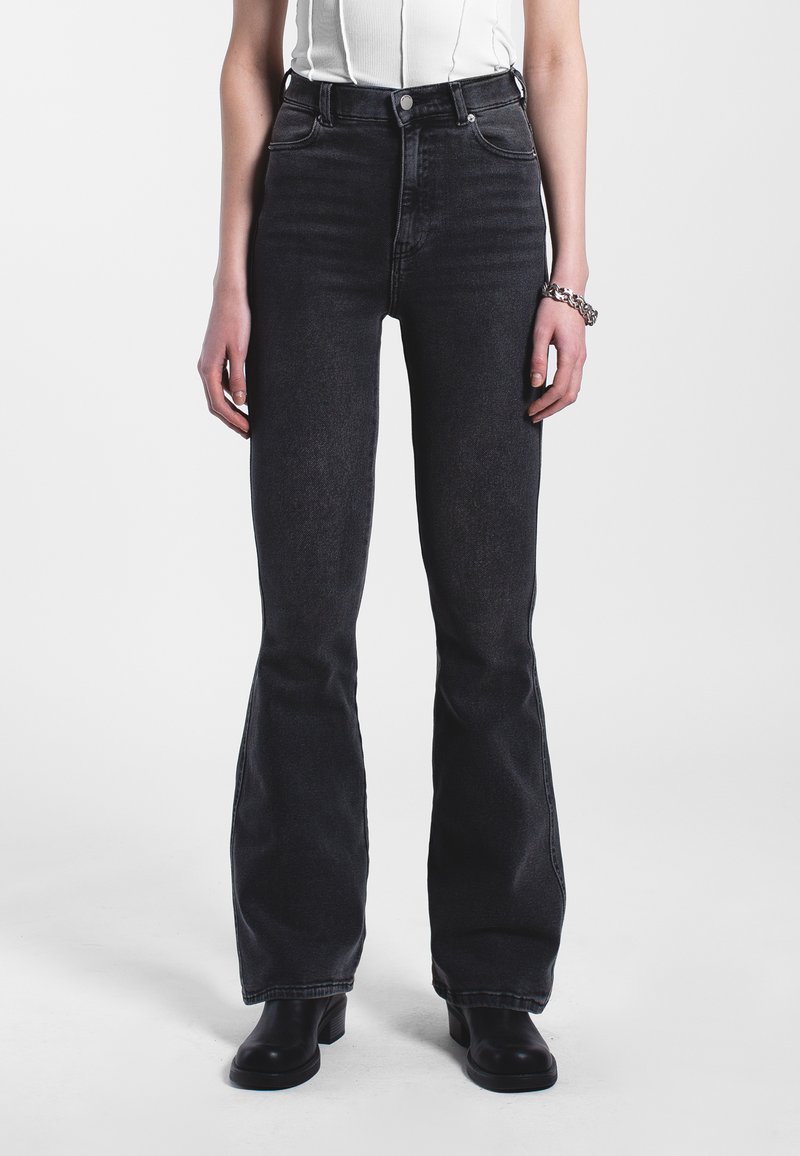 Korkeavyötäröiset mustat leveälahkeiset farkut, jotka on valmistettu denimmateriaalista. Niissä on klassinen viisi-taskuinen muotoilu ja hienovaraiset tikkausjatkumoita.