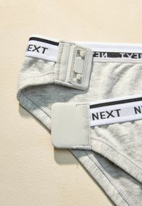 Gray cotton briefs featuring a white elastic waistband with black "NEXT" lettering, including a fabric tag and snap closure.