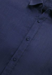 Marineblauwe overhem Shirt met een gladde textuur, een gespreide kraag en zes bijpassende knopen. De stof heeft een subtiele glans en een kreukvrije afwerking.