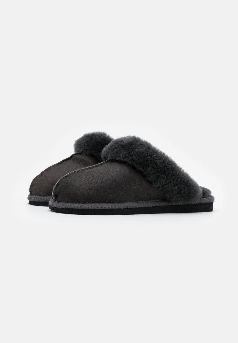 Schwarze Wildlederhausschuhe mit einem plüschigen, dunkelgrauen Schaffellaufschlag, einem runden Zehendesign und einer flachen Gummisohle. Weicher Stoff und warme Optik.