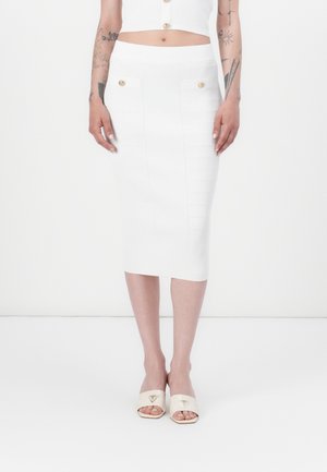 White ribbed knit midi skirt with a fitted silhouette, textured design, and two gold button accents at the front pockets.
