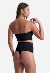 Costume da bagno nero a due pezzi con top senza spalline e slip a vita alta, caratterizzato da una texture liscia e un design minimalista.