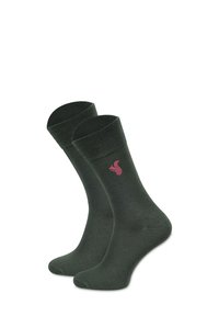Oliwkowe skarpetki wykonane z miękkiego materiału, z prążkowanym ściągaczem i małym logo różowej wiewiórki z boku. Długość do połowy łydki, gładka tekstura.
