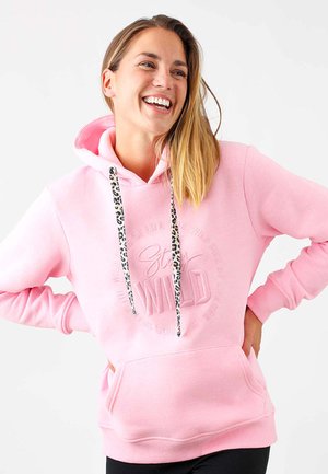 Roze hoodie met een kangoeroezak, voorzien van drawstrings in luipaardprint en reliëflettering met de tekst "Stay Wild." Zachte stof textuur.