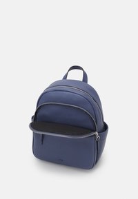Zaino in pelle blu navy con doppi scomparti con zip, una maniglia superiore e una tasca frontale. Texture liscia e design minimalista.