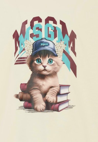 Beige t-shirt met een afbeelding van een kitten die een blauwe pet met parelaccenten draagt, zittend op gestapelde boeken, met kleurrijke letters.