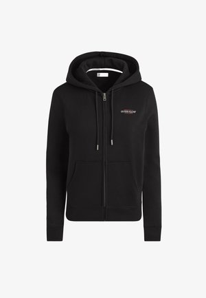Črna zip-up kapuca iz mehkega materiala, ki je opremljena z vrvico za nastavljanje kapuce, kenguru žepom in vezenim logotipom "GUESS JEANS" na prsih.