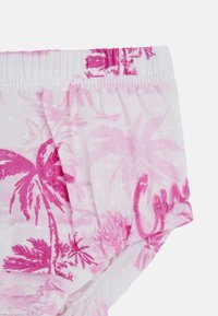 Costumi da bagno per bambini in rosa e bianco con motivo a palma, vita elastica e dettaglio arricciato. Tessuto morbido con una leggera texture.
