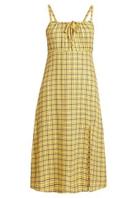 Vestido amarillo a cuadros con tirantes finos, cuerpo fruncido y una abertura lateral. Hecho de tela ligera, presenta patrones de cuadros en negro y amarillo oscuro.