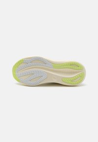 Sole of athletic shoe in cream, white, and light green. Features textured grooves and patterned rubber for grip and flexibility.